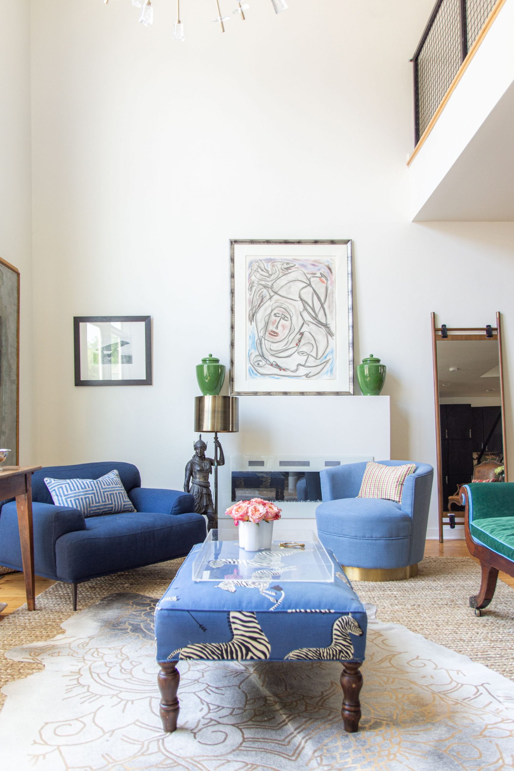 Double-story living room with blue sofa, green chaise, cowhide rug, Article Abisko chair, and sputnik chandelier by Kevin O'Gara on Thou Swell #livingroom #livingroomdesign #homedecor #interiordesign #homedesign #homedecorideas