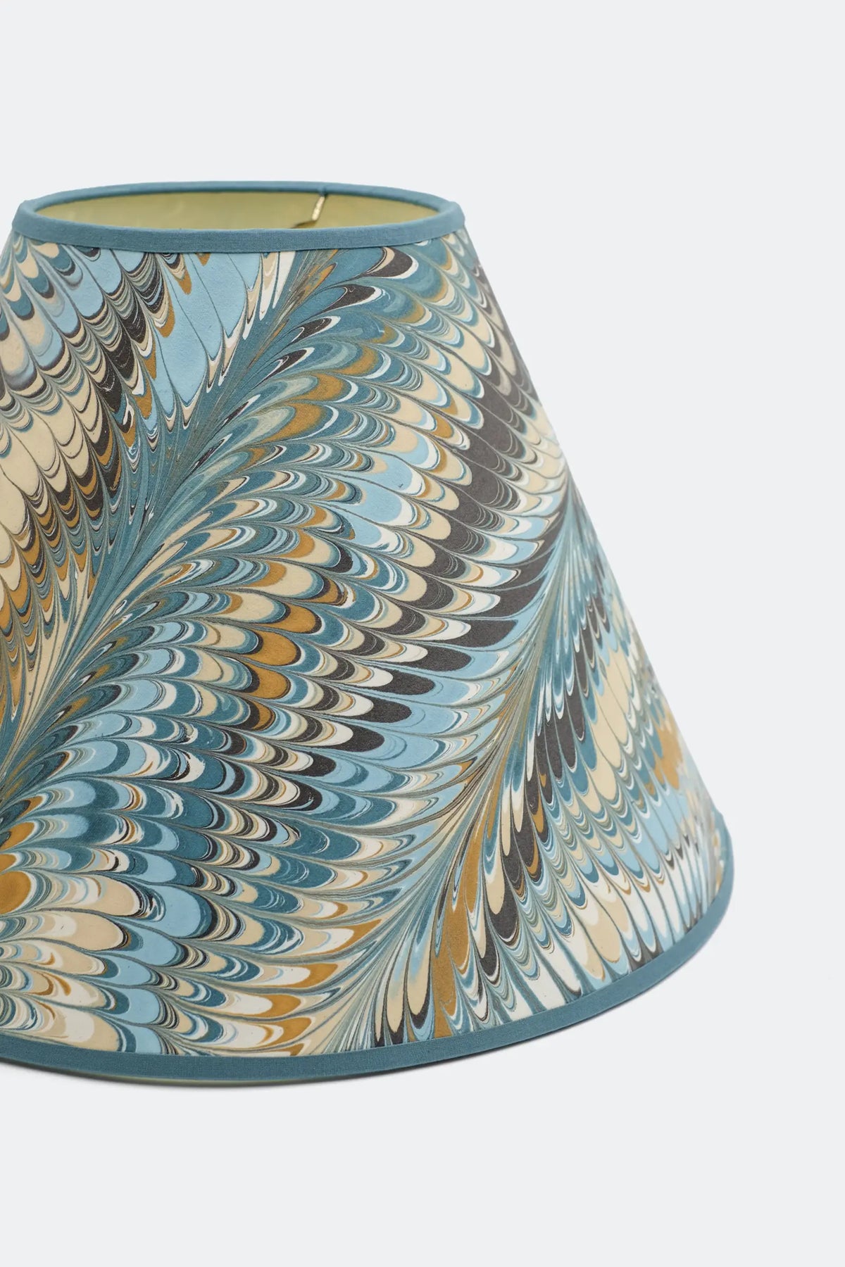 Close view of the Kelmscott marbled lamp shade showing the combed feather pattern in blue, ochre and cream.