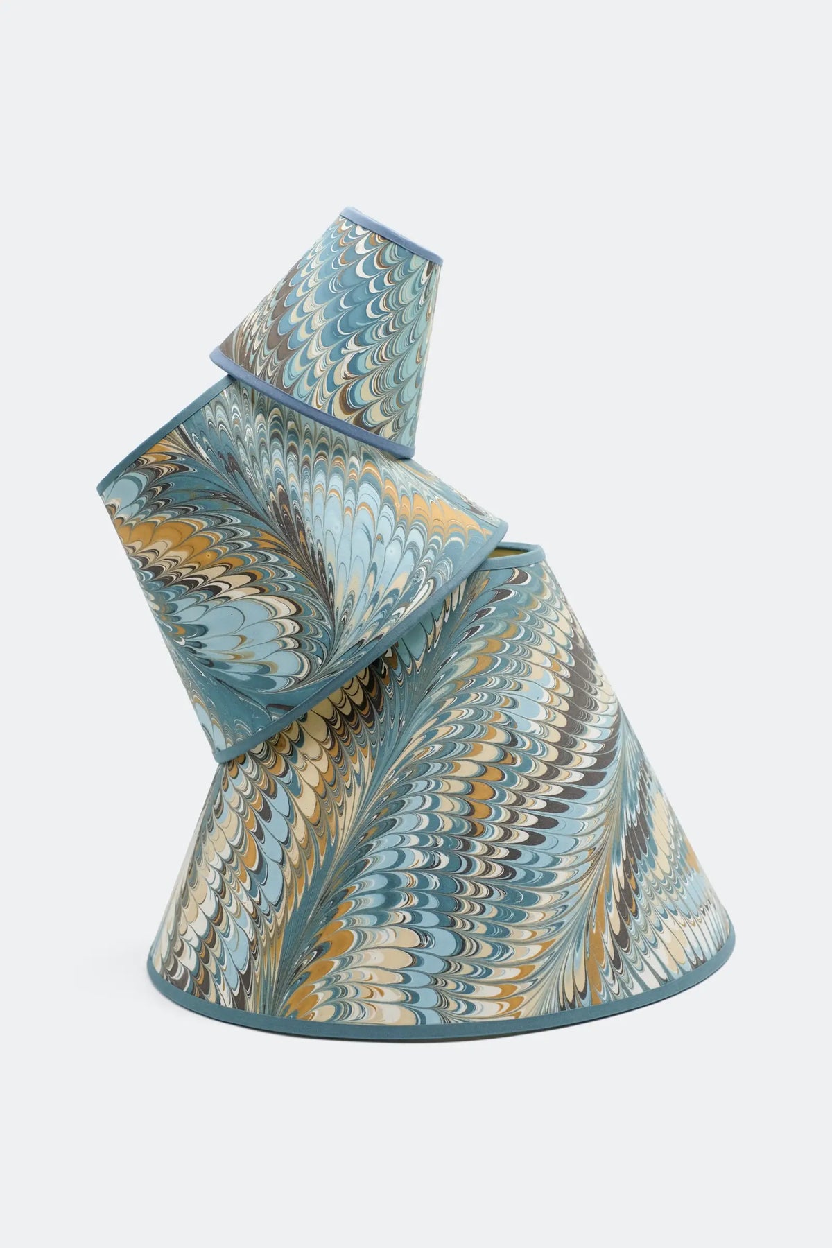 Two Kelmscott hand-marbled empire lamp shades stacked, showing how the feather marbling varies from shade to shade.