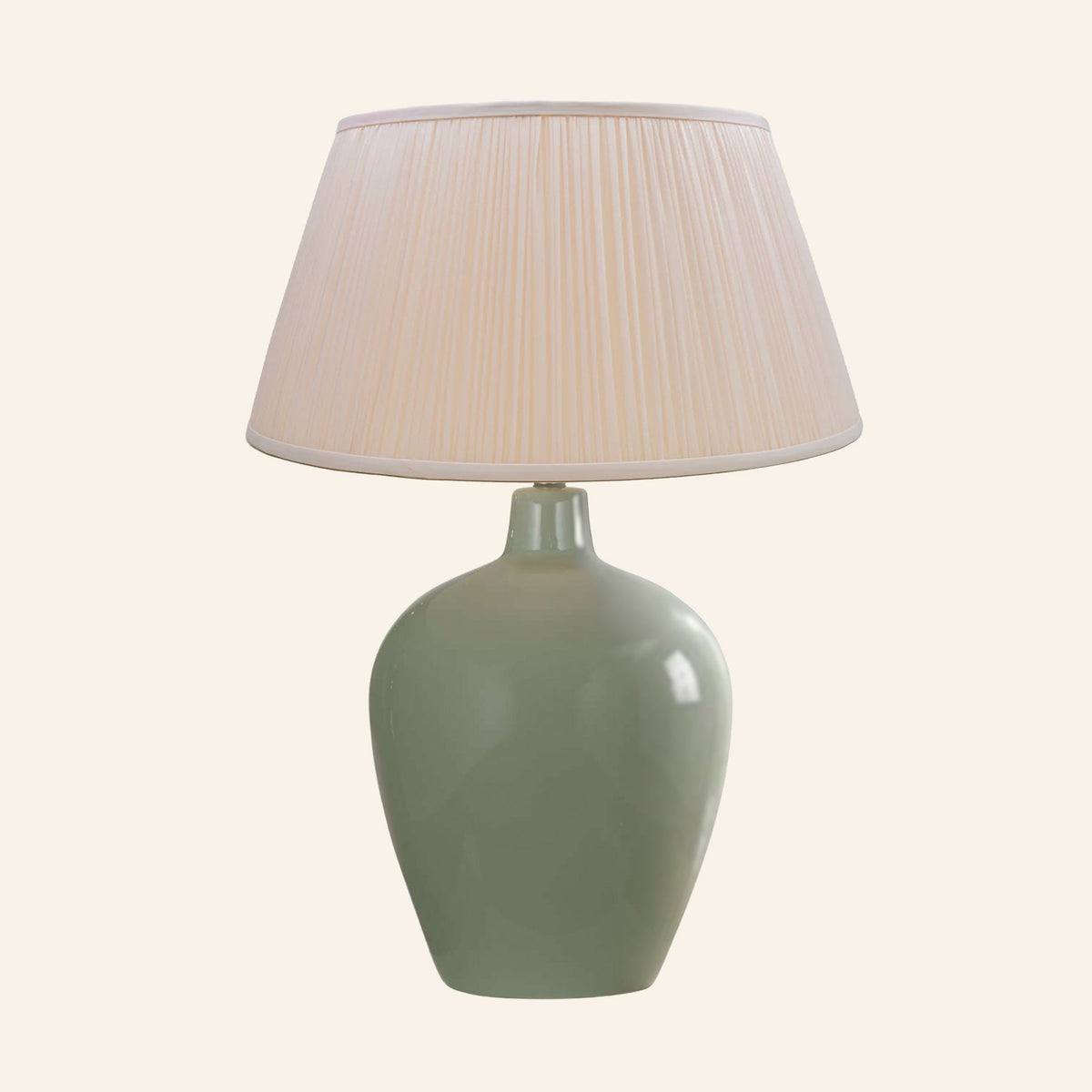 Ansley moss green ceramic table lamp with a Park Peach silk pleated shade.