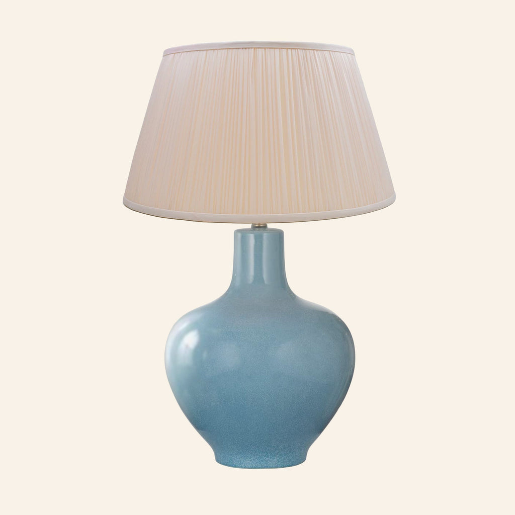 Celeste aqua blue glazed ceramic table lamp with a Park Peach silk pleated shade.