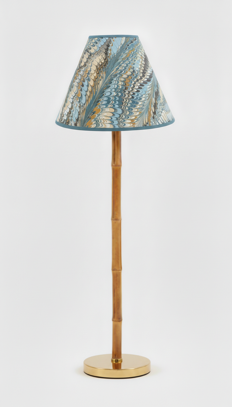 Kelmscott blue and gold marbled lamp shade shown on a slim brass faux bamboo lamp base.