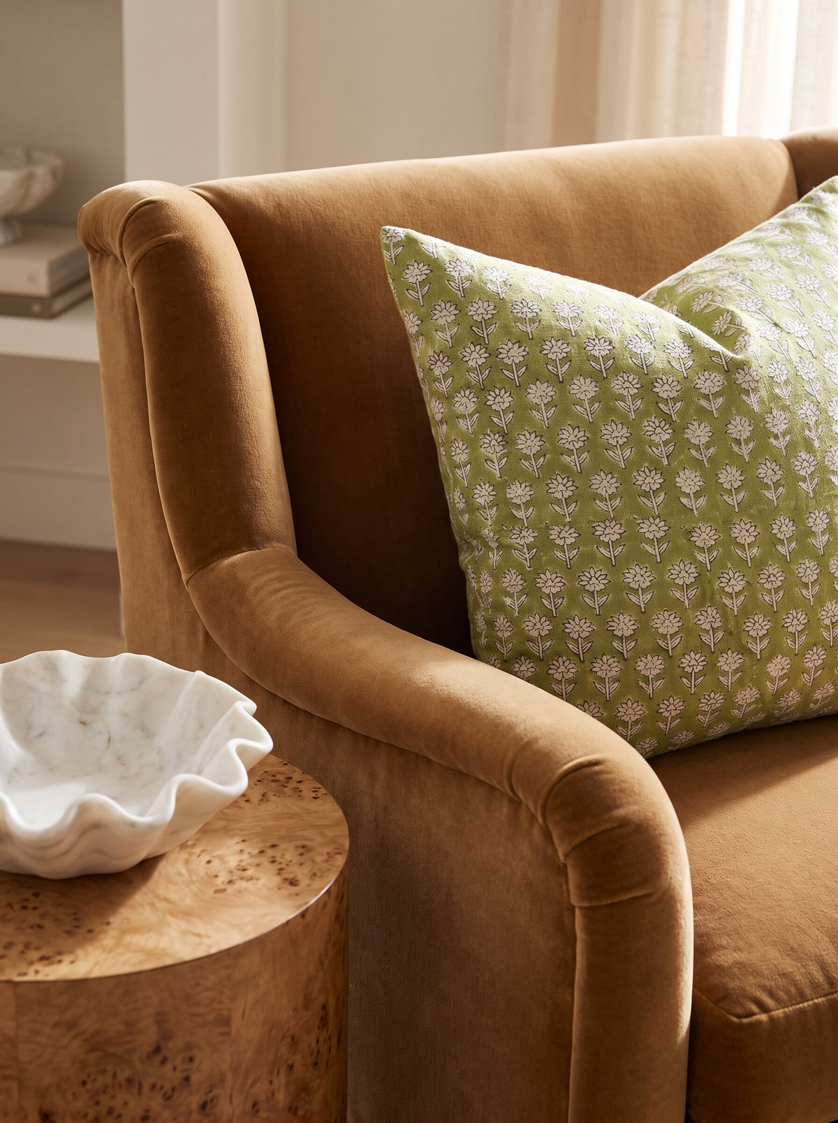 The Beechwood block print pillow cover in olive green styled on a camel velvet armchair