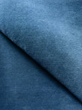 Close-up of a Kevin Francis Design handloomed wool rug in vibrant cobalt blue, showcasing its solid color and textured weave.