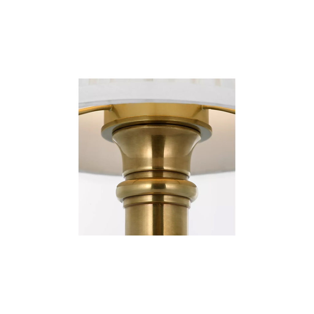 Detail of the turned brass column base and pleated silk shade on the Ellis cordless lamp by Kevin Francis Design