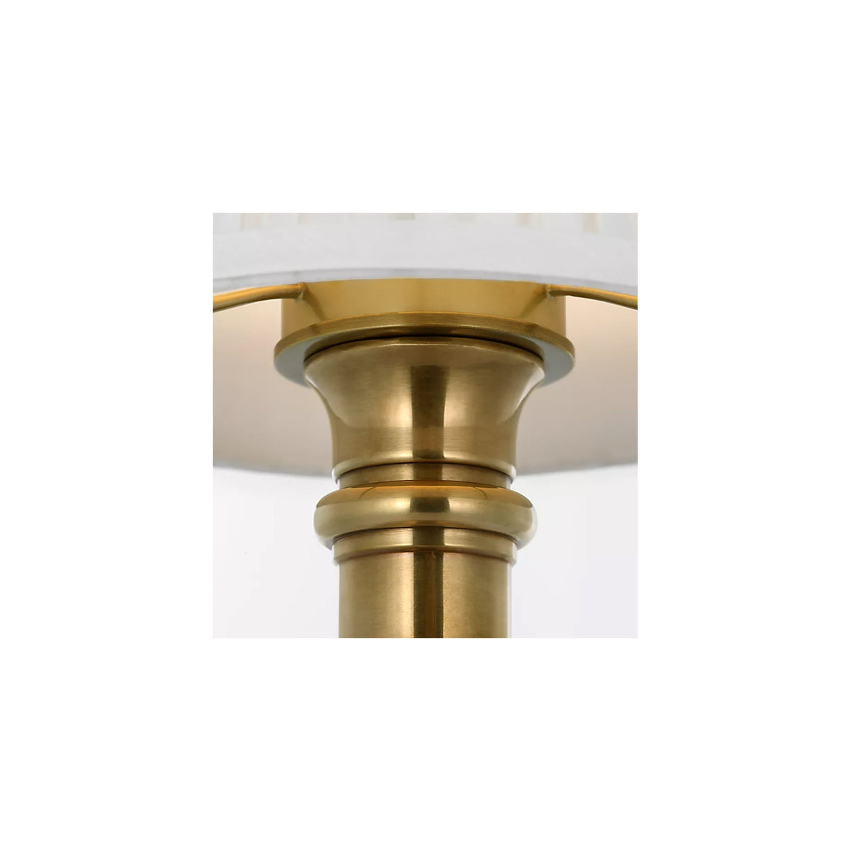Detail of the turned brass column base and pleated silk shade on the Ellis cordless lamp by Kevin Francis Design