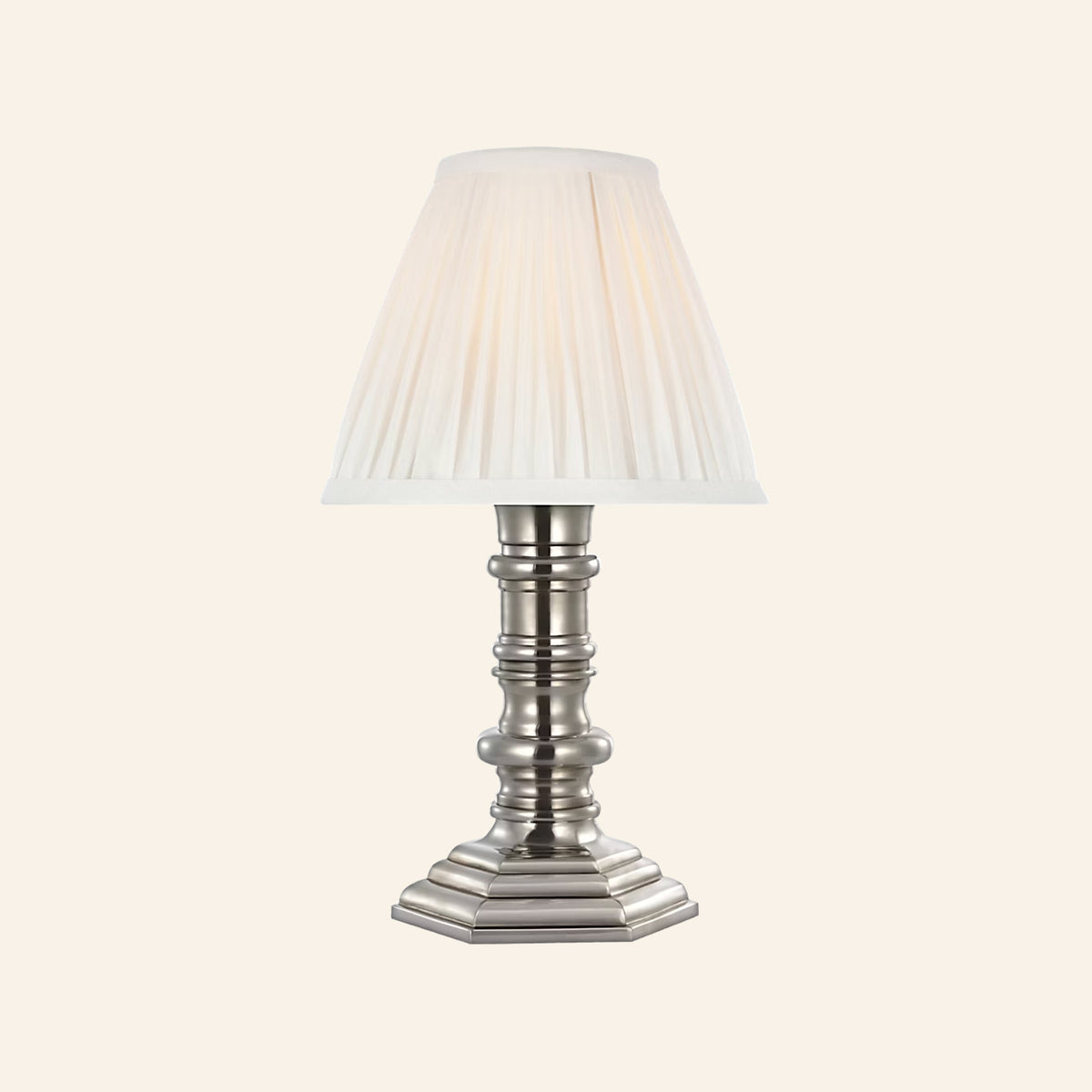 12-inch Ellis cordless candlestick lamp in polished silver with a turned column base, stepped octagonal foot and white pleated silk shade, by Kevin Francis Design