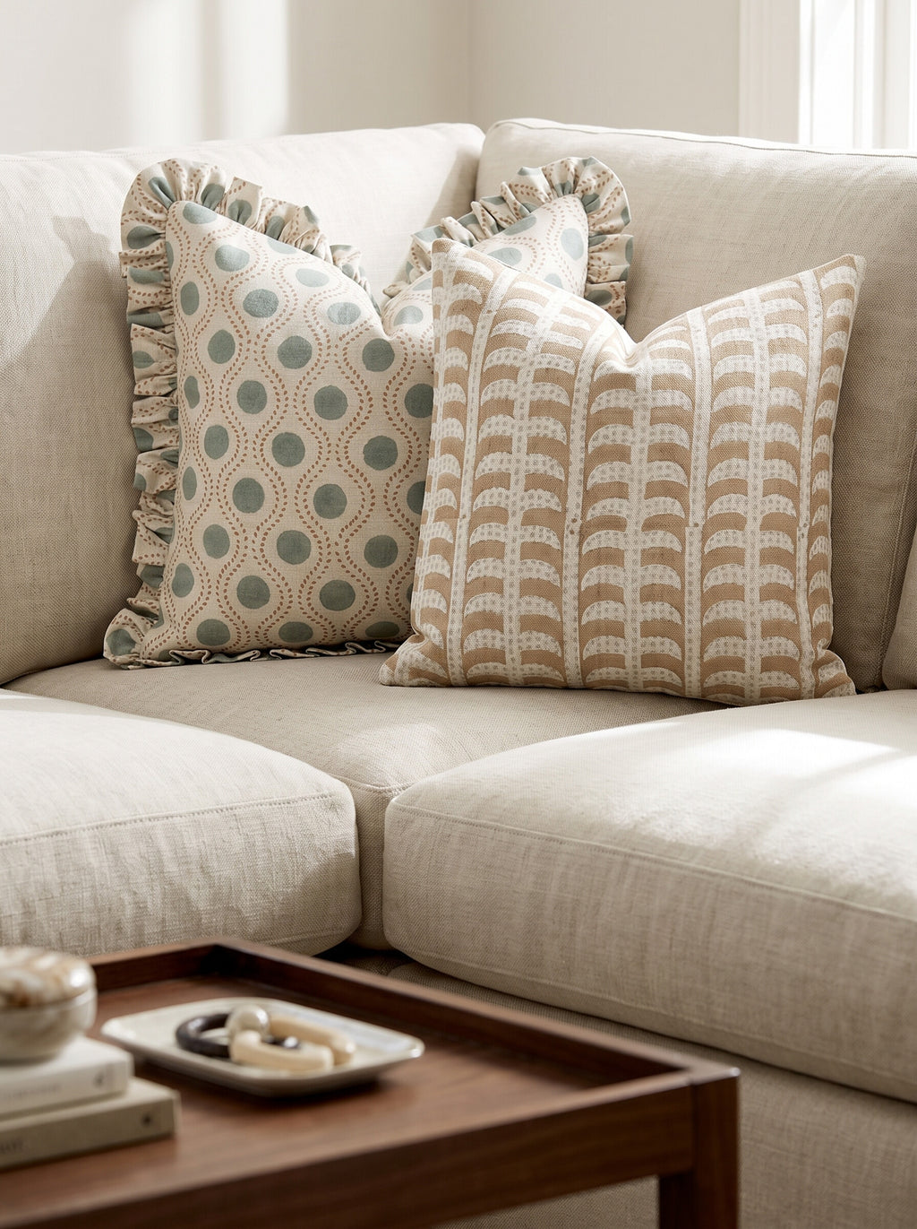 The Glenridge and Hanover ruffled block print pillow covers styled together on a cream linen sofa