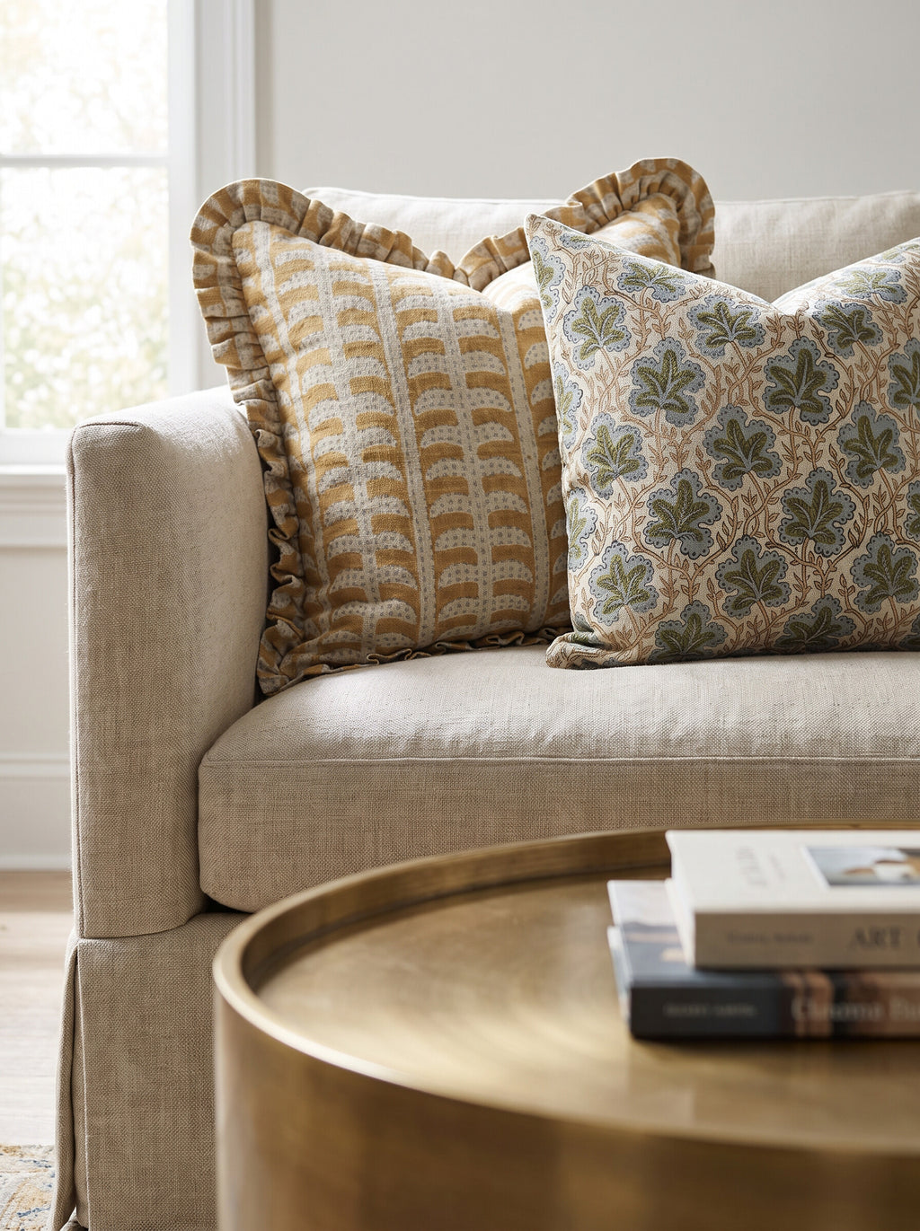 The Hanover ruffled and Longleaf block print pillow covers styled together on a linen sofa