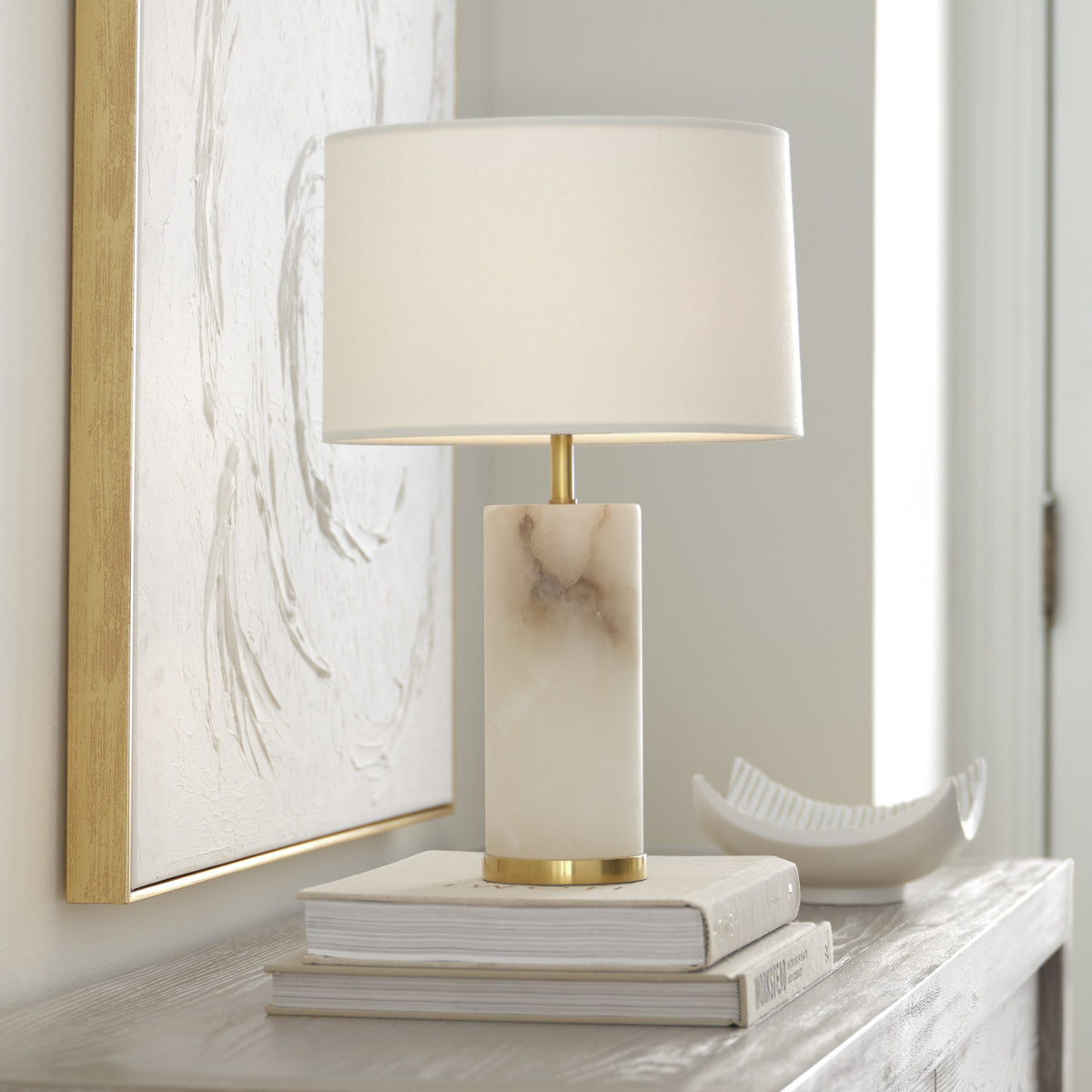Hayes alabaster cordless table lamp styled with books on a sideboard by Kevin Francis Design