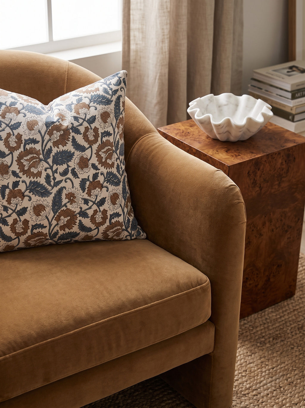 The Paces block print pillow cover in brown and slate blue styled on a camel velvet sofa