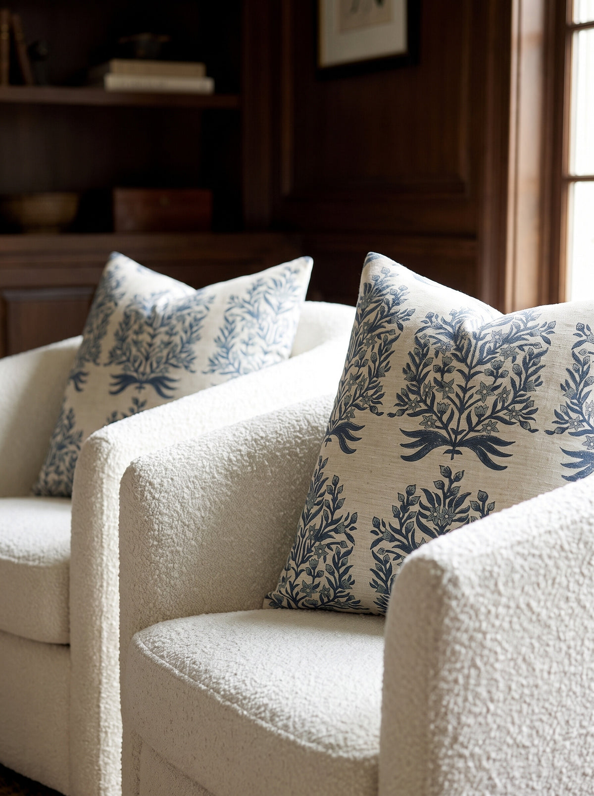 Two Randall block print pillow covers in indigo and white styled on cream boucle swivel chairs
