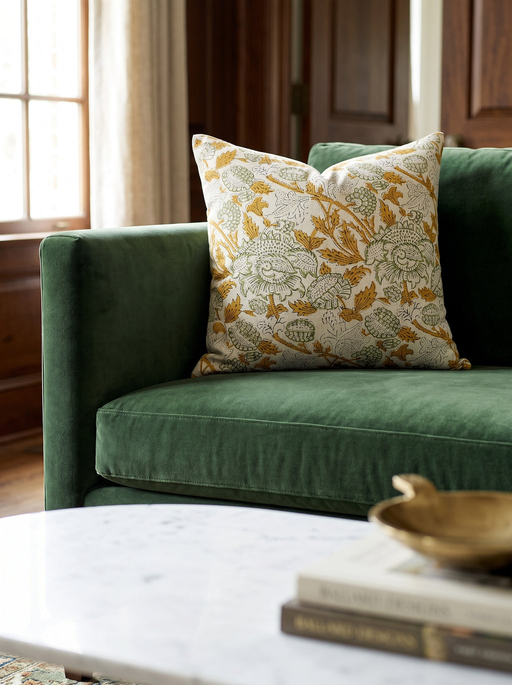 The Rumson block print pillow cover in mustard and sage styled on a green velvet sofa