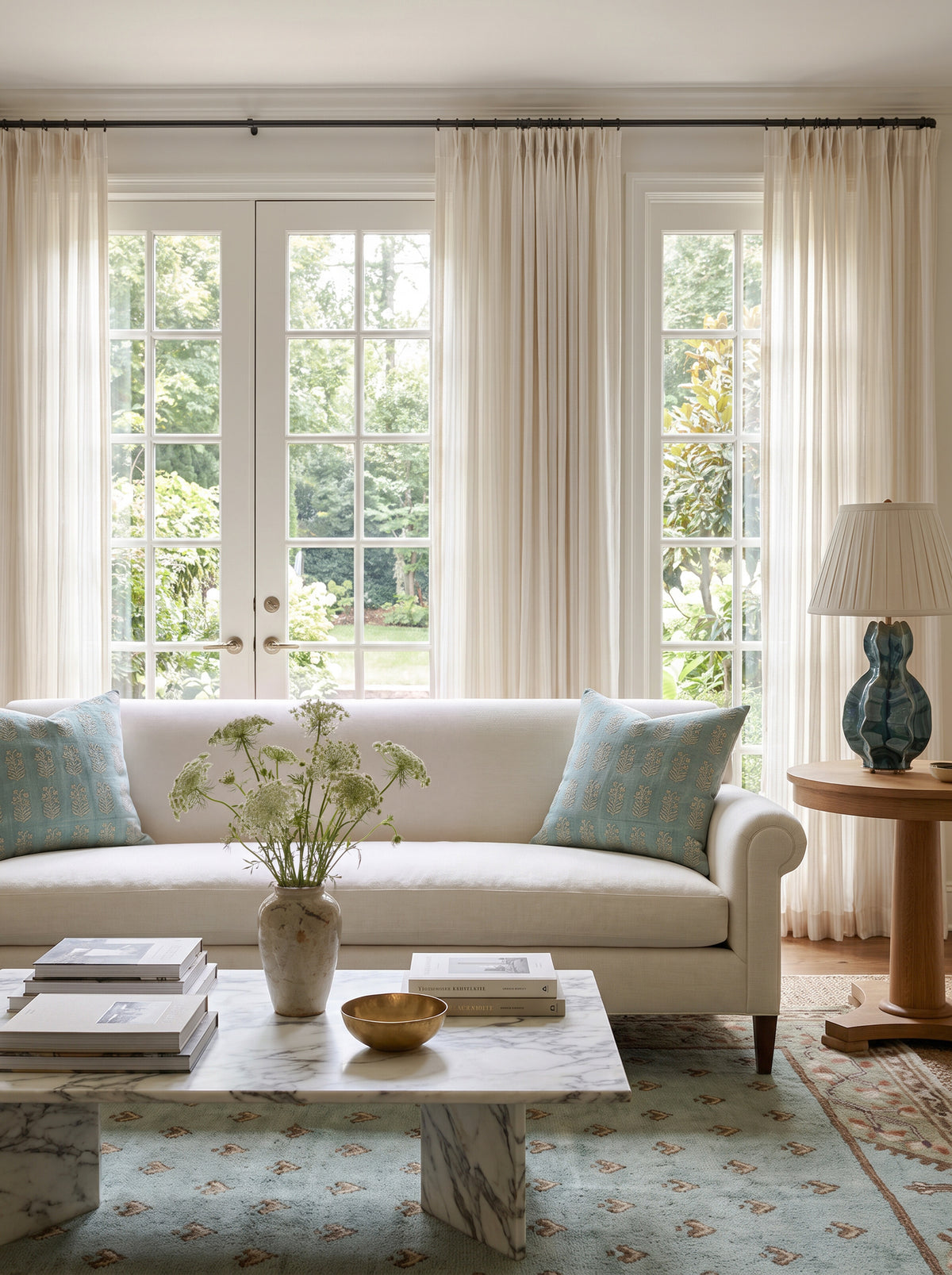 Woodward block print pillow covers in aqua on a cream sofa beside the Aurelia teal ceramic table lamp