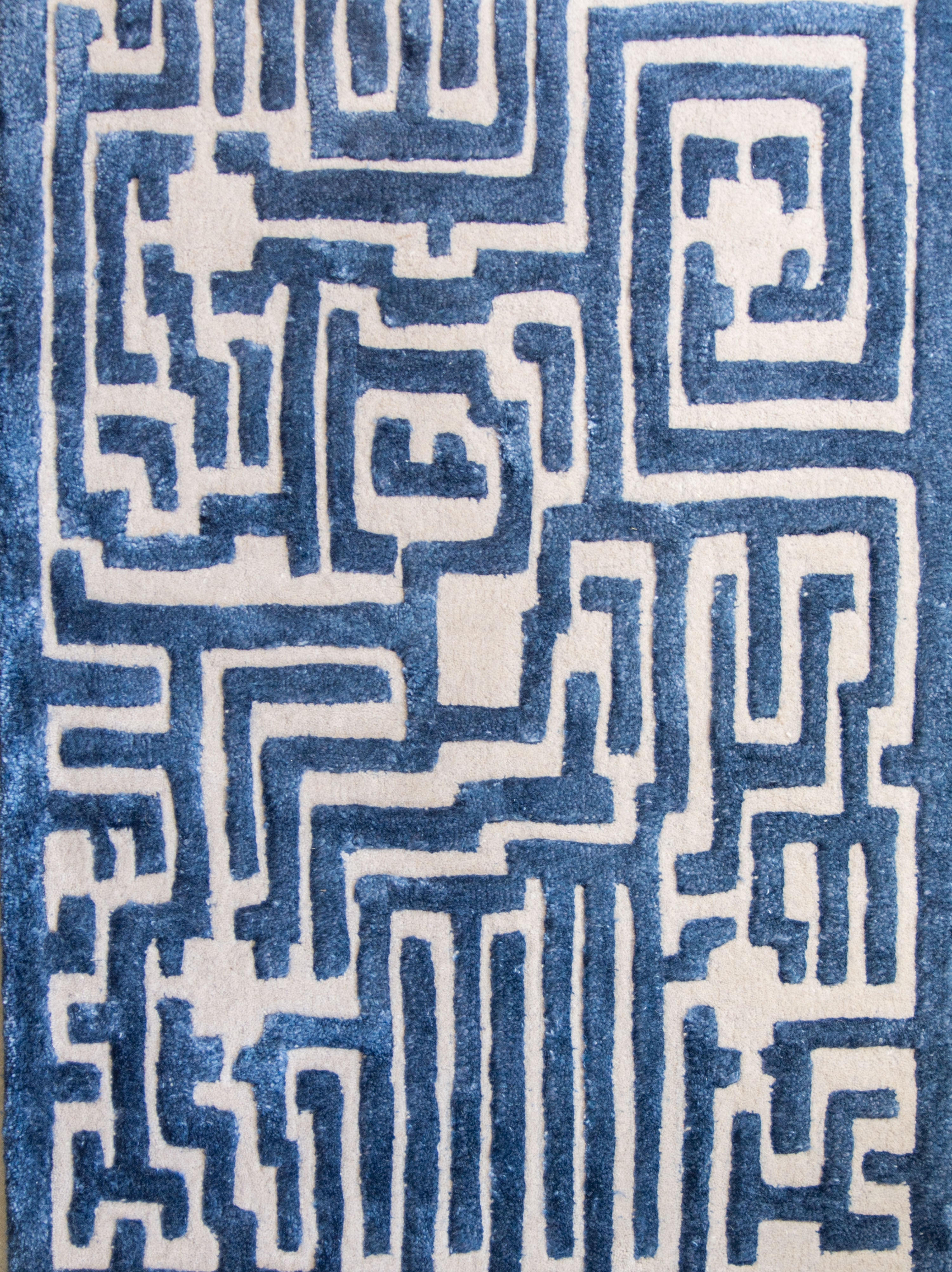 Maze luxury floor rug with a blueberry blue border outlining a beige maze